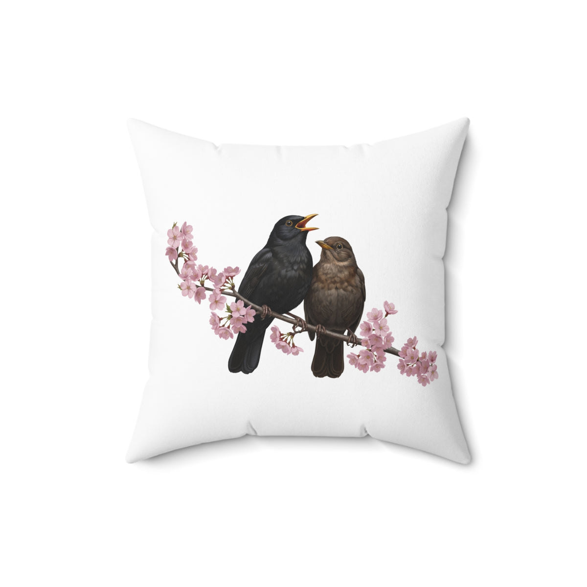 White pillow with black birds on a branch with cherry blossoms design on a white background