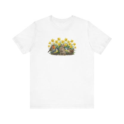 Weißes T-Shirt mit großem Frühlings-Aufdruck: Ein Kaninchen sitzt zwischen gelben Osterglocken, umgeben von Rotkehlchen, Blaumeise, Kohlmeise und Zaunkönig.