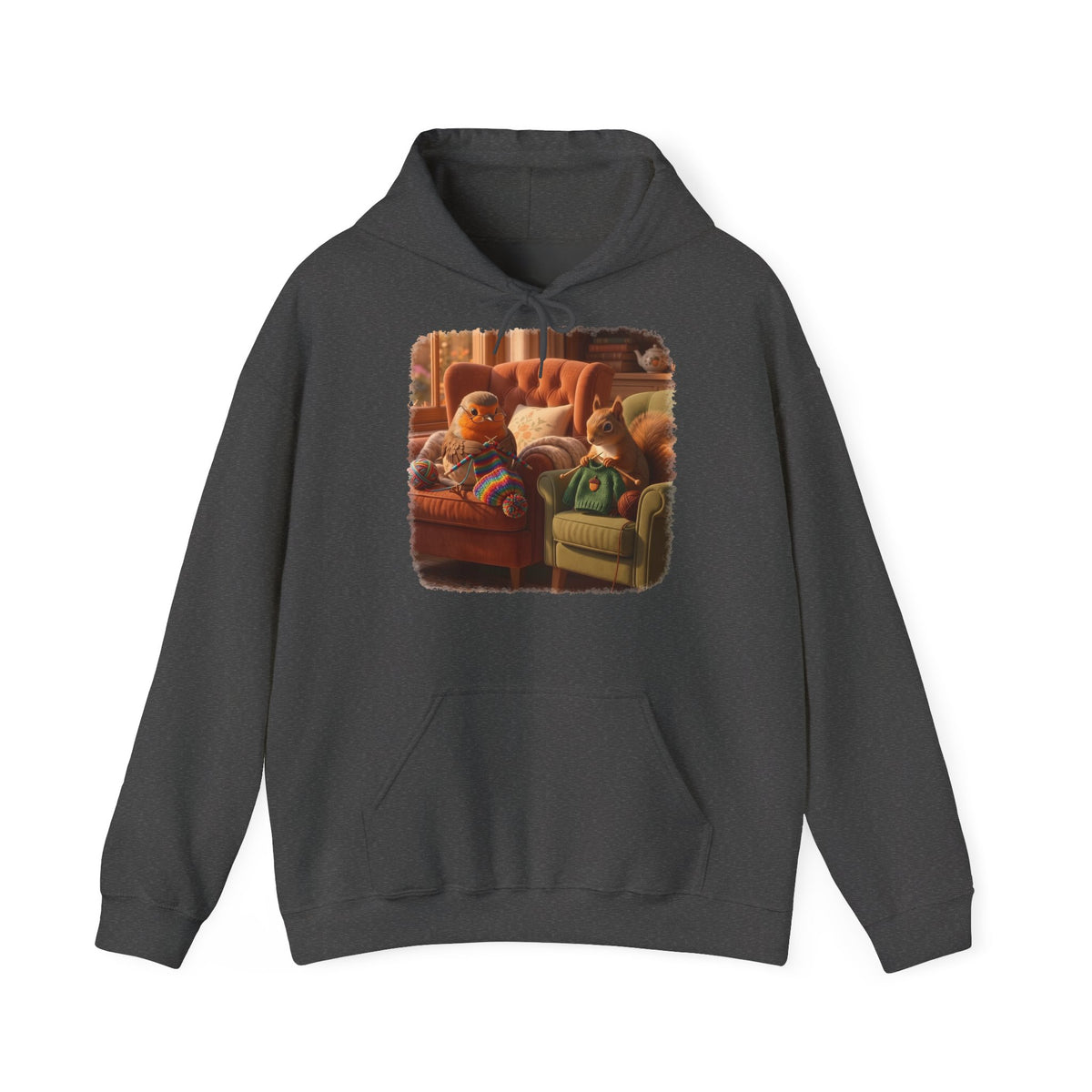 Ein dunkelgrauer Kapuzenpullover mit einem quadratischen Grafikdruck auf der Brust, der eine gemütliche Wohnzimmerszene zeigt: Ein Rotkehlchen sitzt neben einem Eichhörnchen im grünen Pullover auf einem Sessel, und beide stricken.