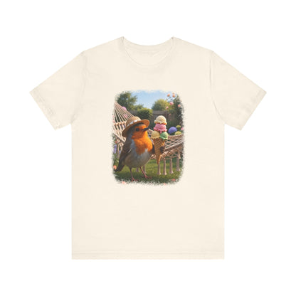 Naturfarbenes T-Shirt aus weicher Baumwolle. Auf der Brust ist eine große, farbenfrohe digitale Illustration aufgedruckt: Das Rotkehlchen Rosi steht mit einem Sonnenhut in einem sommerlichen Garten und hält ein riesiges Eis mit vier Kugeln in den Flügeln.