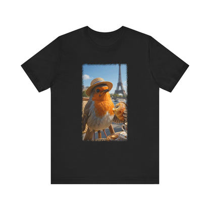 A dark black crewneck t-shirt featuring a rectangular graphic print of a robin wearing a straw hat with the Eiffel Tower and Paris street scene in the background.