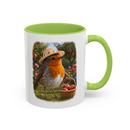 Weiße Keramiktasse mit grünem Henkel und Innenseite. Das aufgedruckte Motiv zeigt eine digitale Illustration von einem Rotkehlchen namens Rosi, das einen Sonnenhut trägt und mit einem vollen Apfelkörbchen im Flügel unter Apfelbäumen steht.