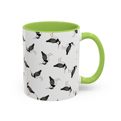 Weiße Keramiktasse mit grünem Henkel und gemaltem Kiebitz-Motiv