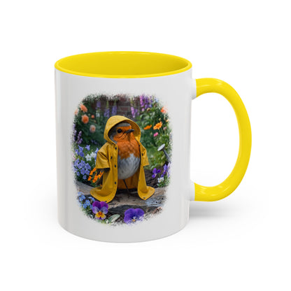 A white ceramic mug with a bright yellow interior, handle, and rim, featuring a printed illustration of a bird in a yellow raincoat surrounded by colorful flowers.