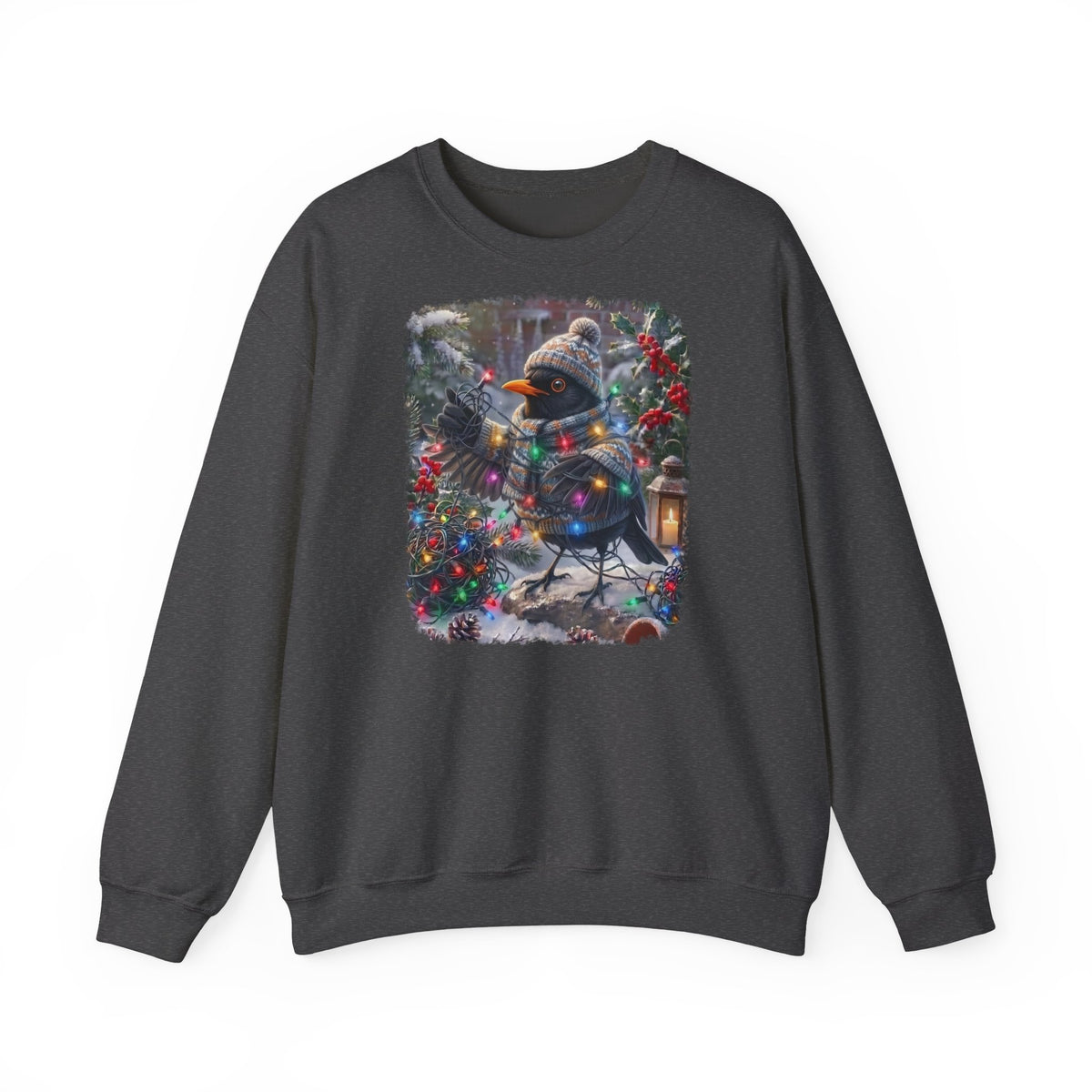 Ein dunkelgraues Sweatshirt mit Rundhalsausschnitt und einem farbenfrohen Grafikdruck: eine Amsel in Winterkleidung und mit Mütze, die inmitten von Weihnachtsbäumen und Schnee eine Lichterkette hält.