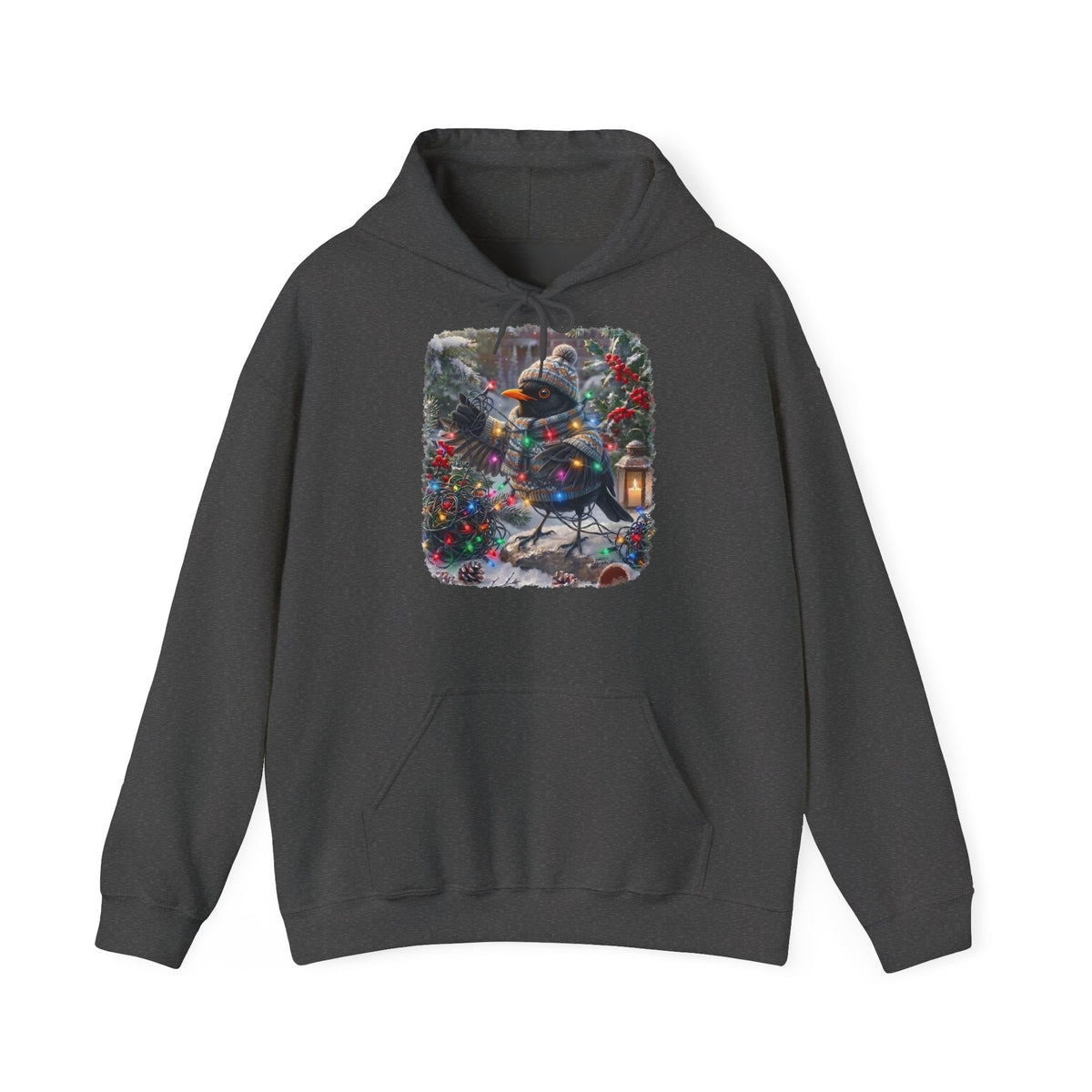 Ein dunkelgrauer Kapuzenpullover und einem farbenfrohen Grafikdruck: eine Amsel in Winterkleidung und mit Mütze, die inmitten von Weihnachtsbäumen und Schnee eine Lichterkette hält.
