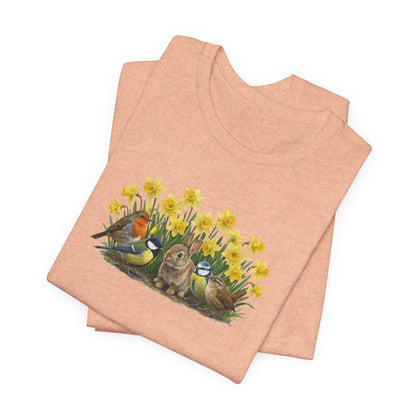 Detailansicht der Aquarell-Illustration auf dem T-Shirt: Fein gezeichnetes Rotkehlchen und Blaumeise sitzen auf Osterglocken-Blüten neben einem braunen Kaninchen.