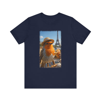 A navy blue short-sleeve crewneck t-shirt featuring a rectangular graphic print on the front. The graphic shows a robin wearing a straw hat with the Eiffel Tower and a street scene in Paris in the background.