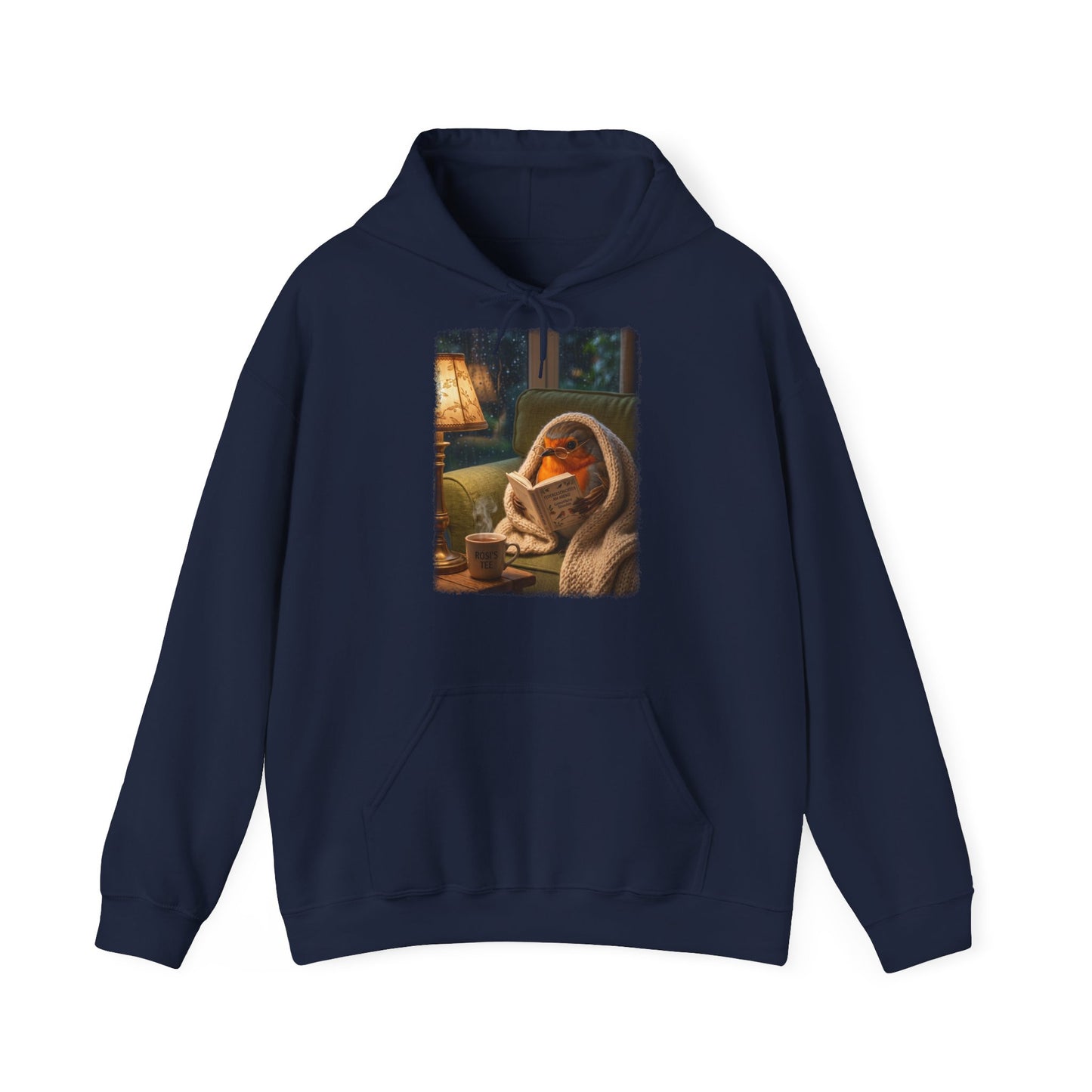 Digital gemalte Illustration eines kleinen Rotkehlchens, das eingekuschelt auf dem Sofa ein Buch liest, gedruckt mit weichen Acryl-Kanten auf einem gemütlichen Unisex-Hoodie mit Kängurutasche.