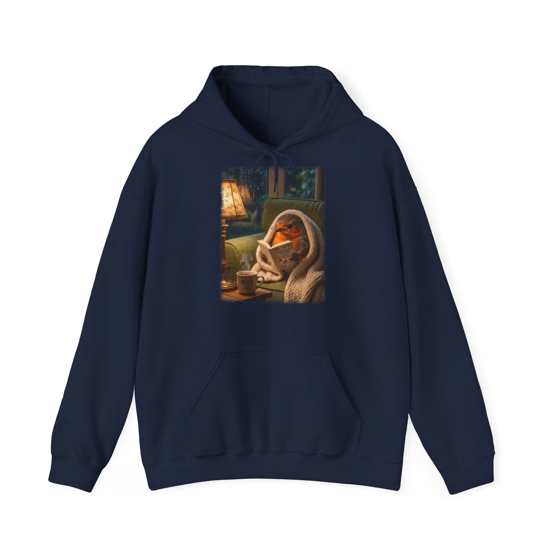 Digital gemalte Illustration eines kleinen Rotkehlchens, das eingekuschelt auf dem Sofa ein Buch liest, gedruckt mit weichen Acryl-Kanten auf einem gemütlichen Unisex-Hoodie mit Kängurutasche.