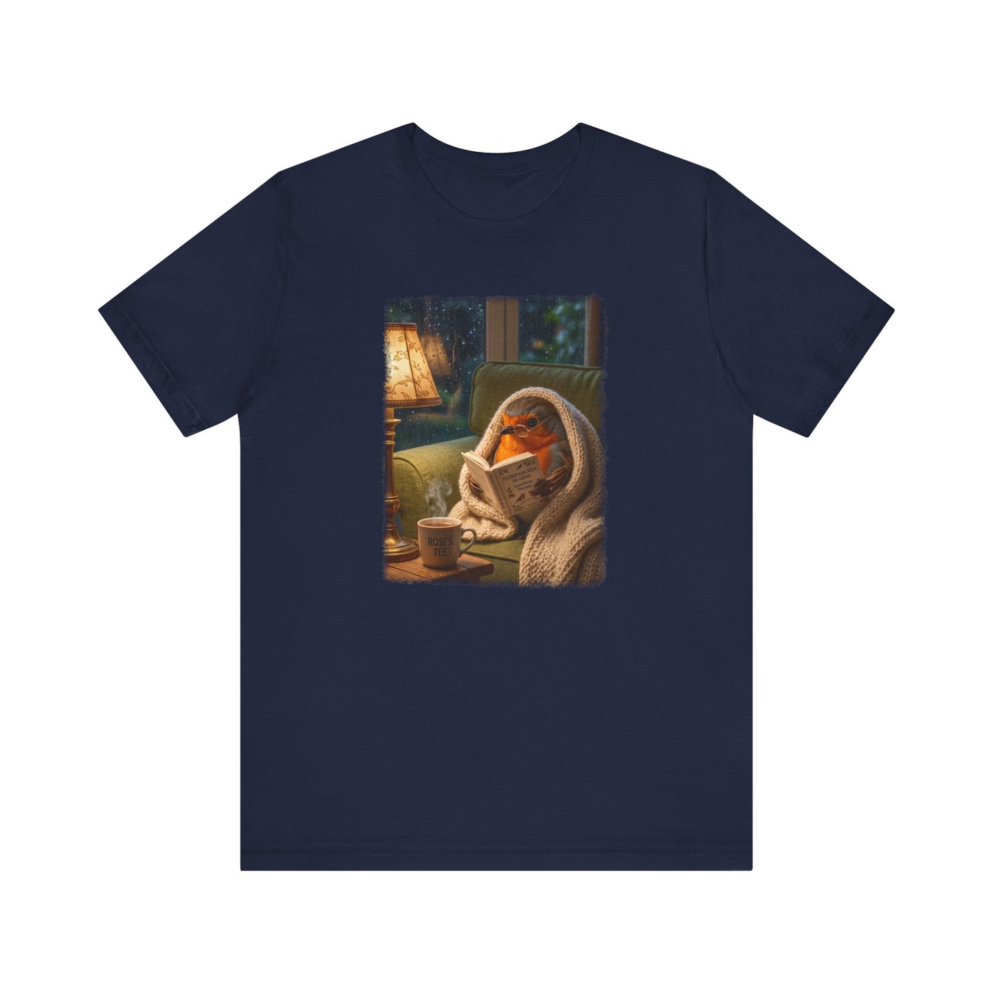 Digital gemalte Illustration eines niedlichen Rotkehlchens, das eingekuschelt in eine Decke auf dem Sofa sitzt und ein Buch liest, mit sanft auslaufenden künstlerischen Acryl-Pinselkanten auf einem T-Shirt.