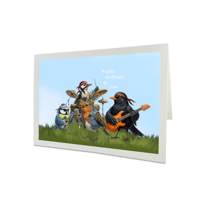 Birthday card with cartoon birds playing music on a grassy field