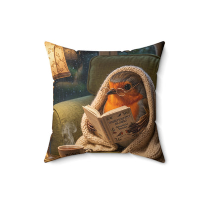 Gemütliches 40x40 cm Dekokissen mit einer digital gemalten Illustration von Rosi Rotkehlchen, das in eine Decke gekuschelt auf dem Sofa ein Buch liest.
