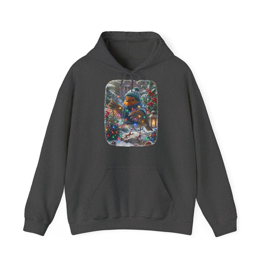 Kuscheliger Winter Hoodie mit Vogelmotiv. Das Rotkehlchen Rosi hat sich beim Schmücken im verschneiten Garten lustig in einer leuchtenden Lichterkette verheddert und versucht den Kabelsalat zu entwirren. Ein schönes Geschenk für Vogelfreunde.