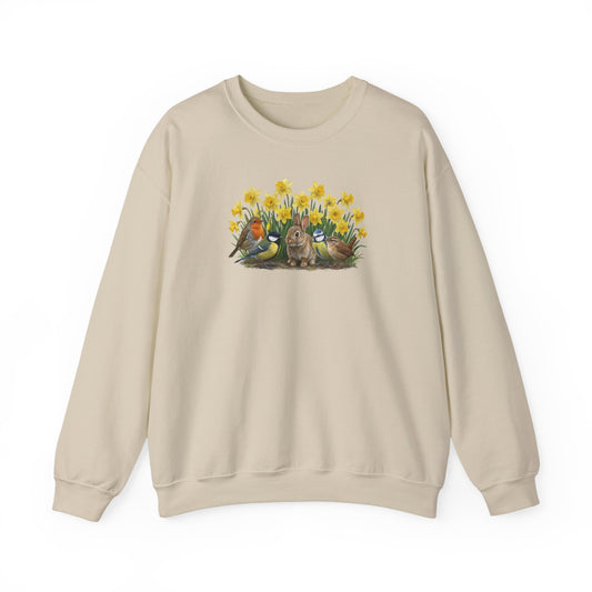 Cremefarbener Sweatshirt mit großem Oster-Motiv auf der Brust: Ein braunes Kaninchen umringt von Rotkehlchen, Meisen, Zaunkönig und gelben Osterglocken.