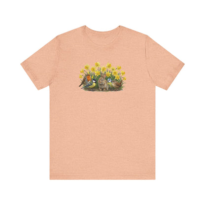 Peach T-Shirt mit großem Frühlings-Aufdruck: Ein Kaninchen sitzt zwischen gelben Osterglocken, umgeben von Rotkehlchen, Blaumeise, Kohlmeise und Zaunkönig.