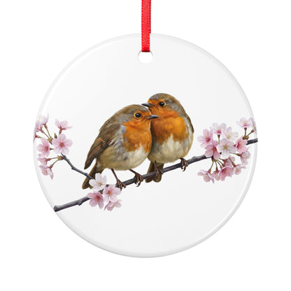 Rundes weißes Keramikornament mit zwei Rotkehlchen, die auf einem Ast mit Kirschblüten sitzen