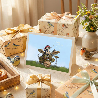 Gifts with bird-themed wrapping paper and a framed card on a decorative table.